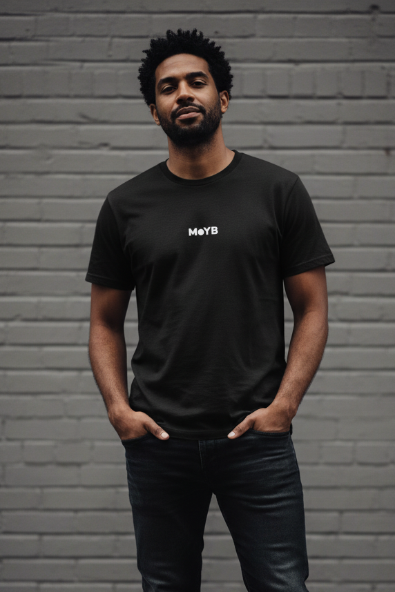Mixed race man in MoYB Everyday Tee Black against grey brick wall